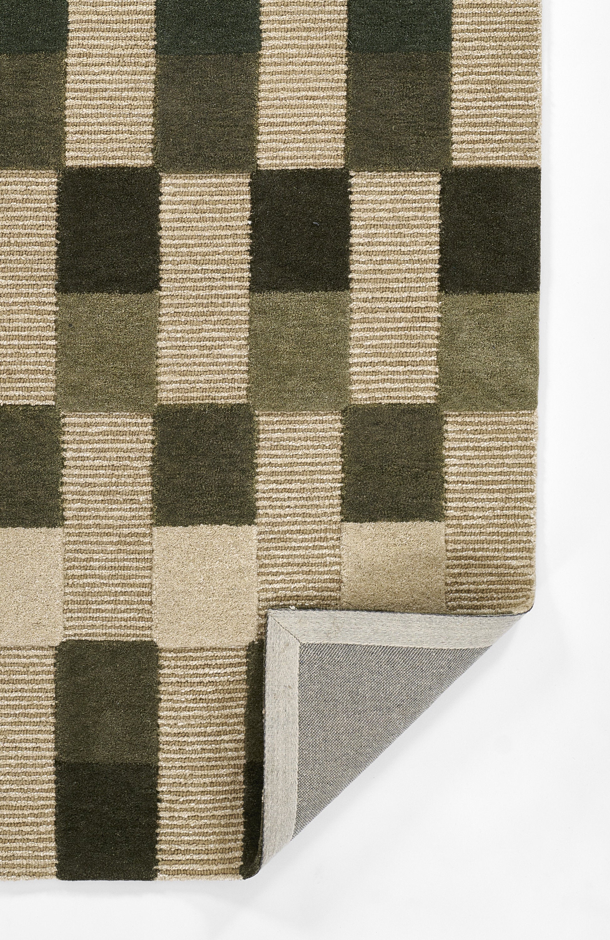 Geometric checker-pattern runner in dark green and beige with a ribbed texture; elongated shape with a corner folded to show gray backing.