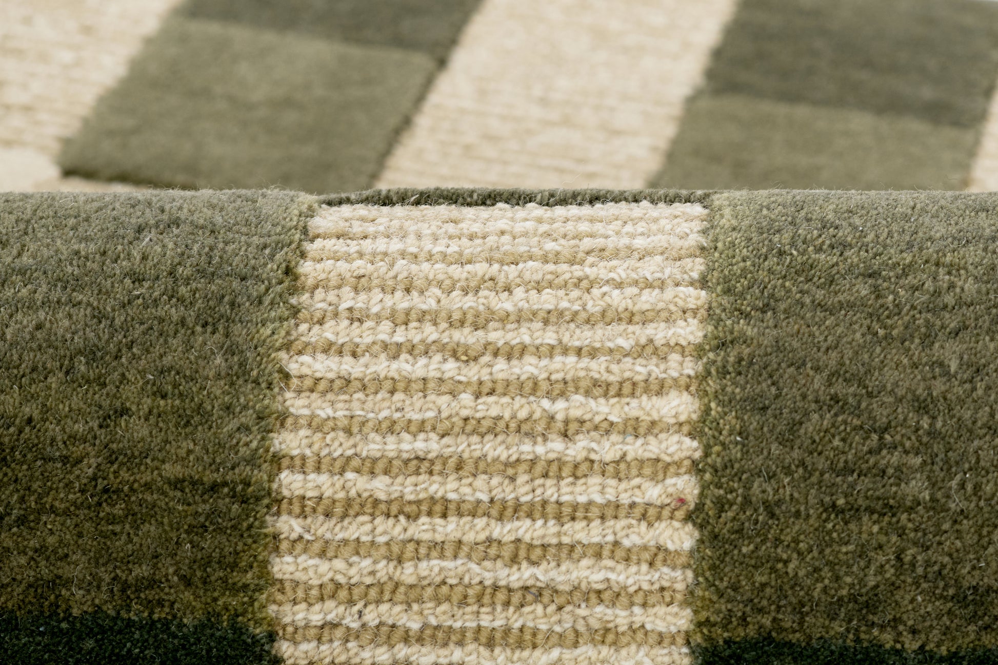 Olive green and beige striped rug with thick textured looped weave and block pattern.