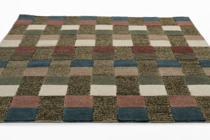 Checkerboard flat-weave rug with small square patches in cream, tan, olive, rust, blue, gray.