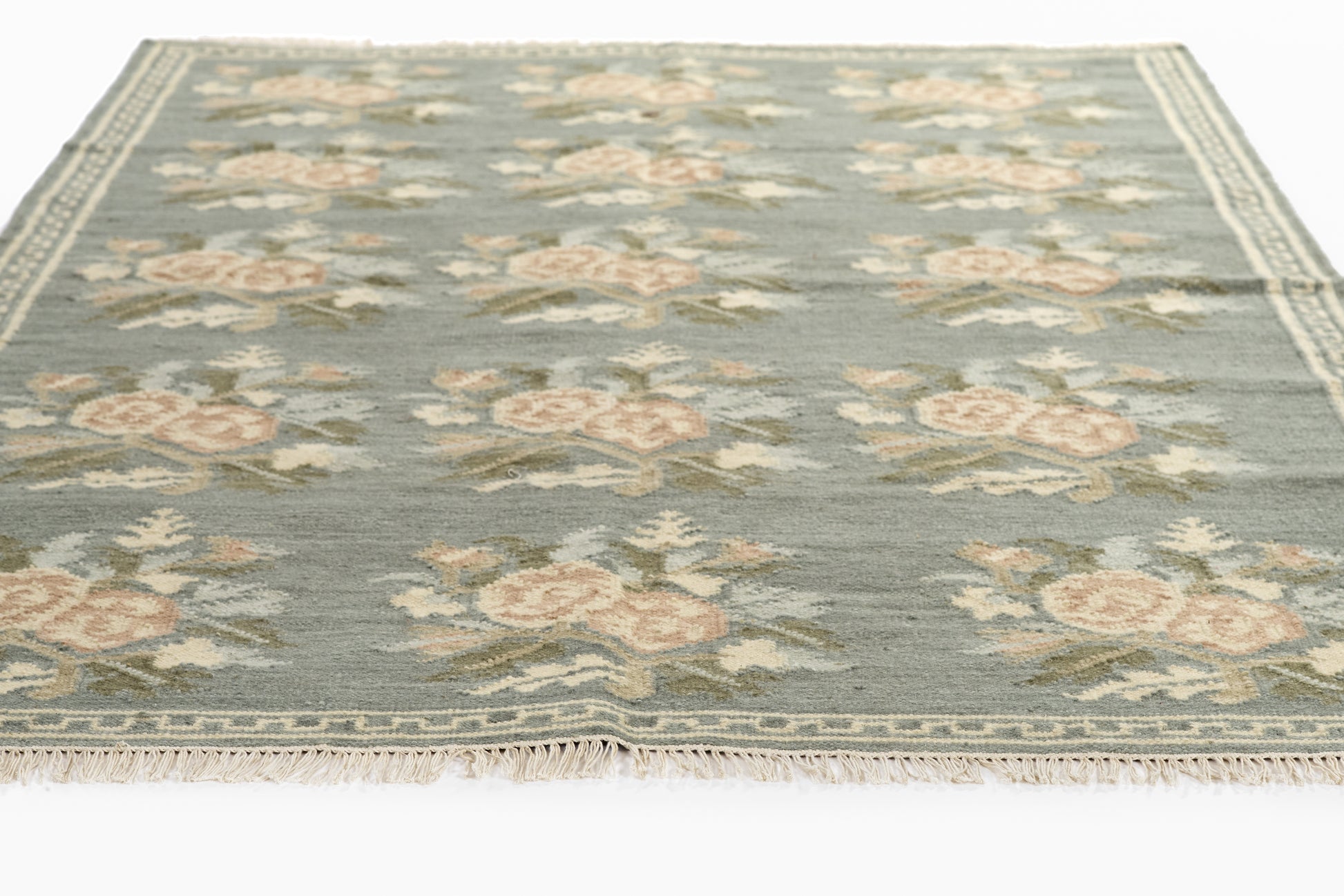 Muted blue floral runner rug with peach roses, cream border and fringe edges in vintage style
