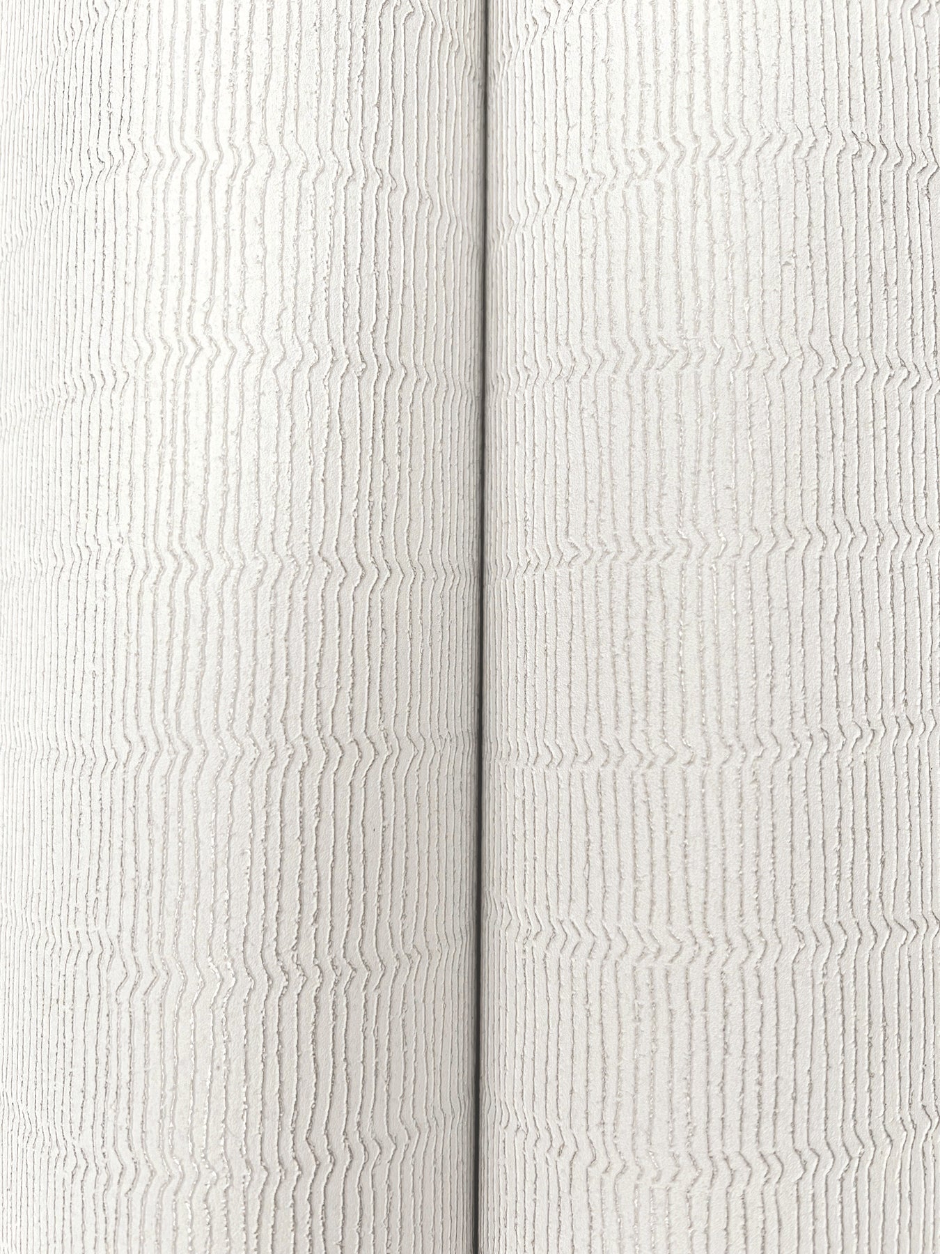 Two ivory textured wallpaper rolls with subtle vertical ribbing; fabric-like wallcovering.
