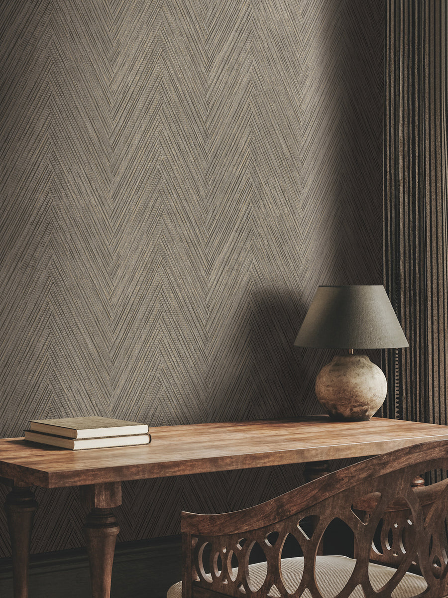 Charcoal textured chevron wallpaper with intricate woven lines, subtle black and gray tones, and delicate metallic gold accents creating a sophisticated herringbone-inspired pattern.