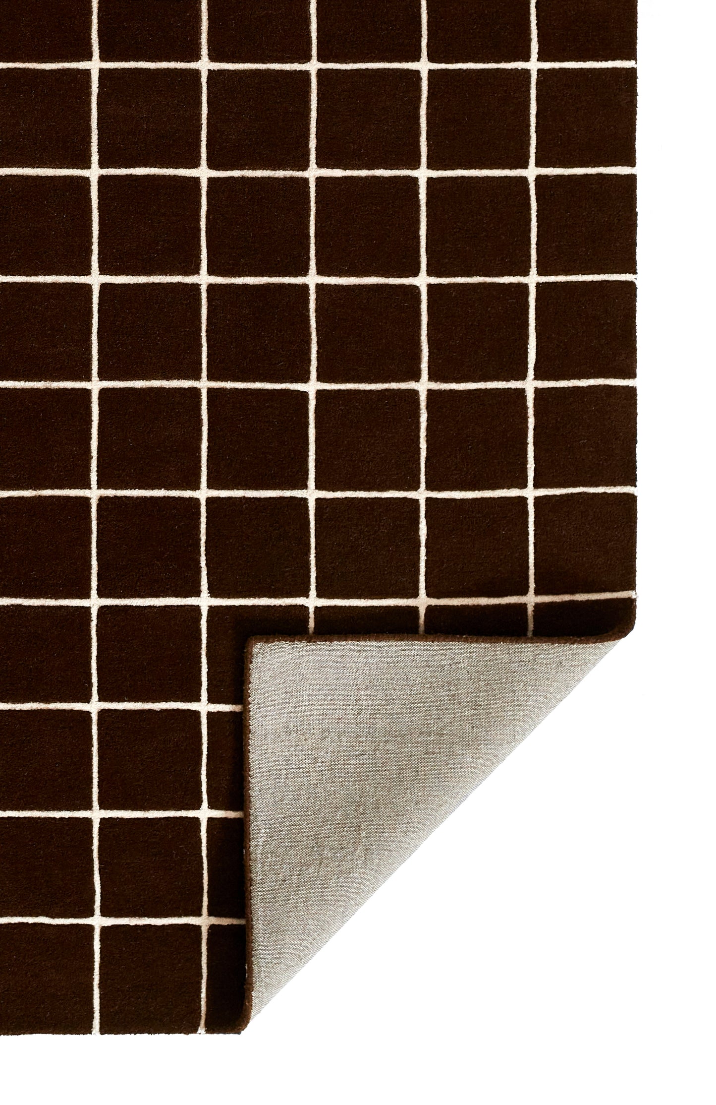 Brown grid-pattern rug swatch with light gray backing; folded corner reveals the backing.
