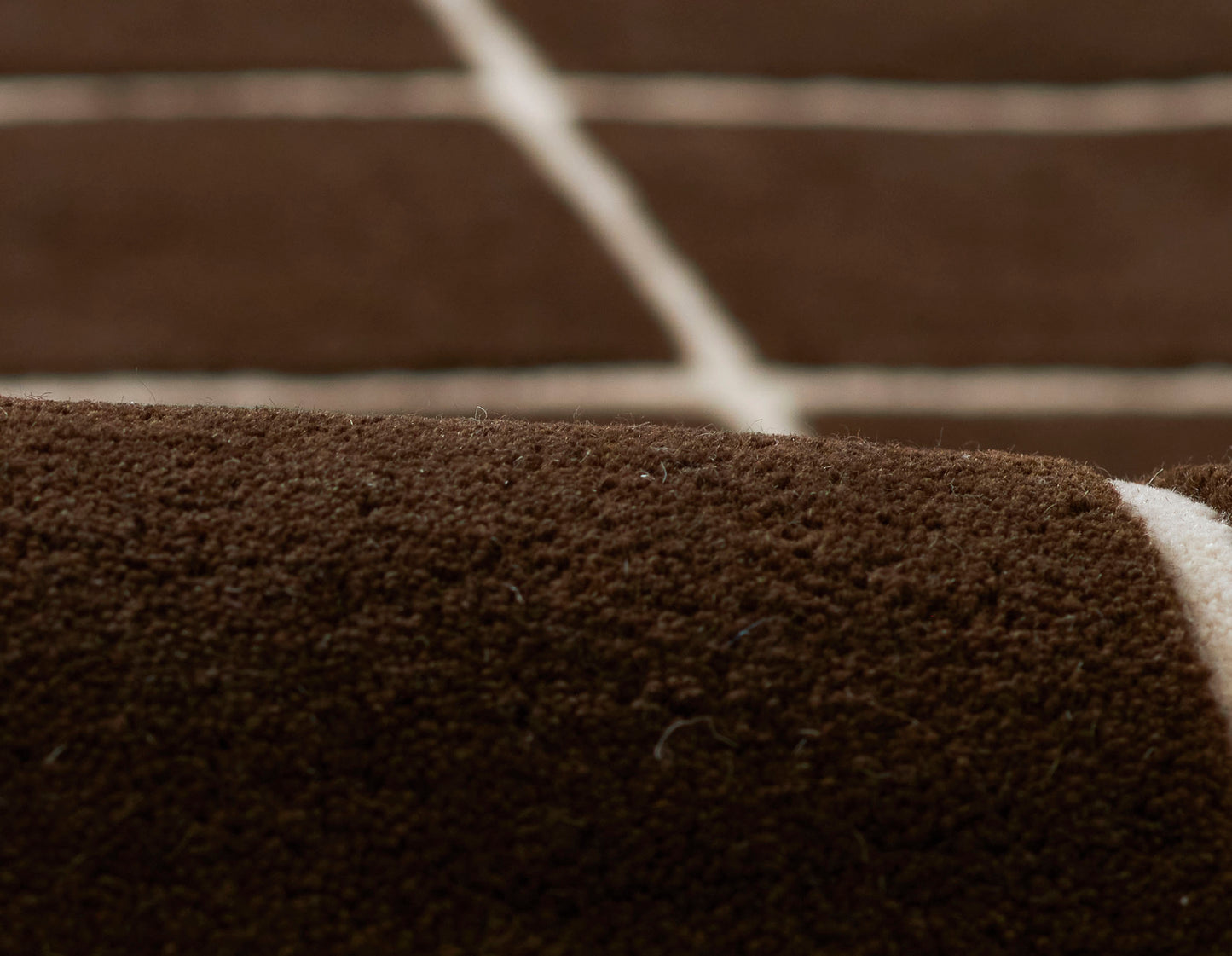 Close-up of dark brown runner rug with a textured loop-pile surface.