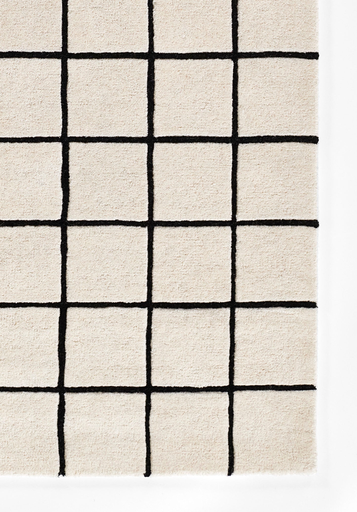 Beige rug with bold black grid lines forming a geometric square pattern