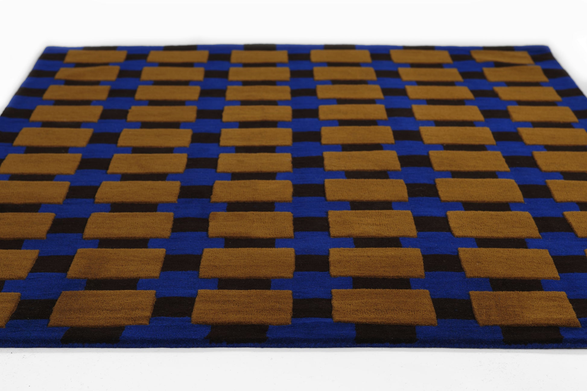 Blue, soft woven rug with tan-brown rectangular blocks in a repeating geometric grid.