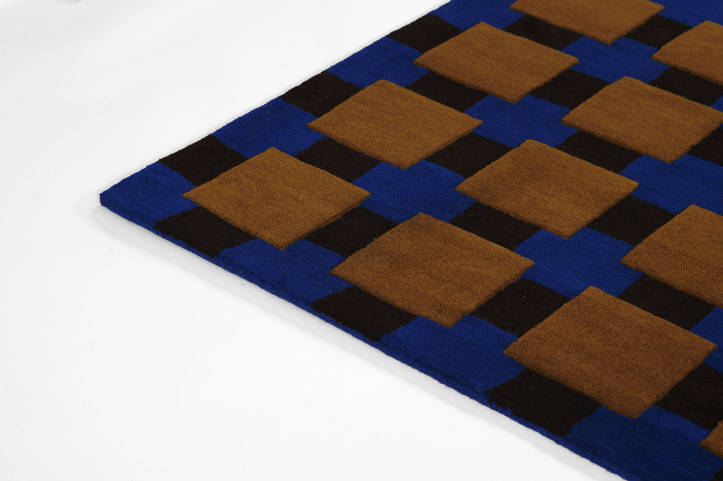 Geometric rug: blue field with brown square patches on a black lattice, soft plush textile.