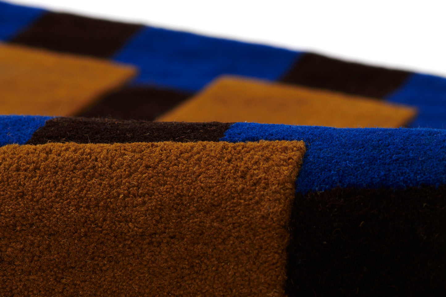 Color-block shaggy rug in blue, brown ochre and black with thick plush pile and geometric square pattern.