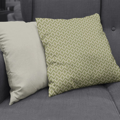 Two decorative cushions on a dark gray sofa: solid cream cushion & green geometric-patterned cushion.