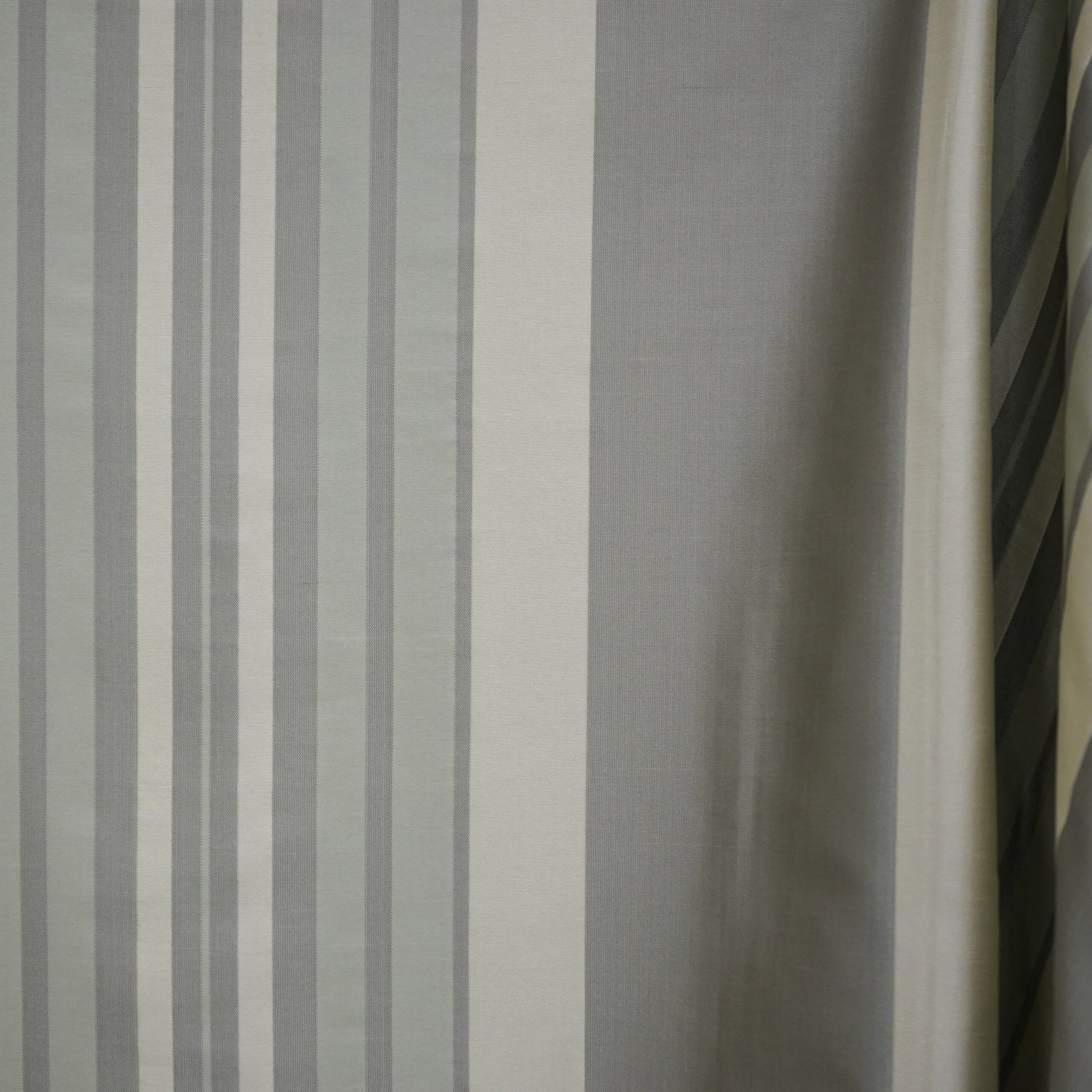 Grey and white vertical striped woven curtain fabric; modern neutral window drape.