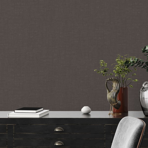 Dark textured backdrop with a sleek black sideboard, brass pulls, stacked books, a white ceramic orb, and a plant vase.