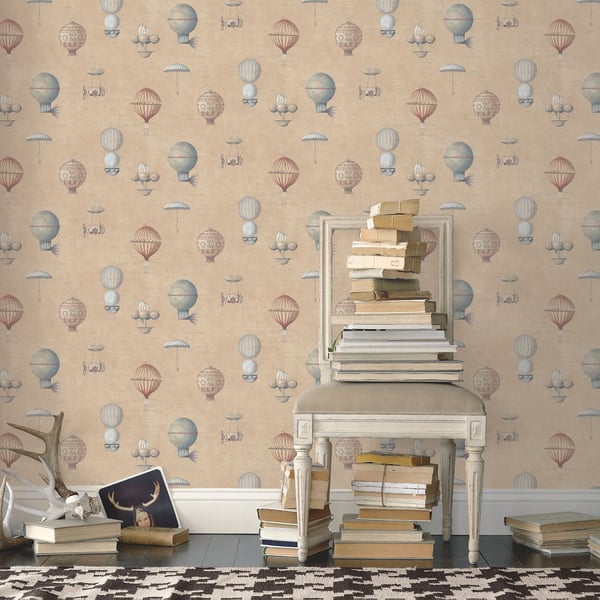 Vintage white chair stacked with books against pastel balloon-pattern wallpaper; extra books on the floor.