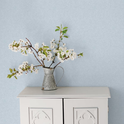 Blue wallpaper with a delicate white floral print.