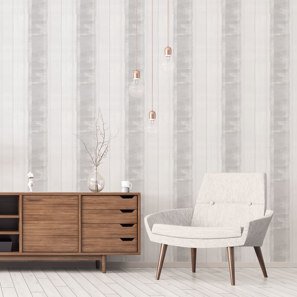 Minimalist living room with striped wallpaper, wooden sideboard, glass vase, pendant lights, and light gray upholstered chair.
