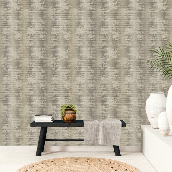 Neutral living room with a beige wall covered in wallpaper; features a black wooden bench, gray throw, potted plant, books, and a round jute rug.