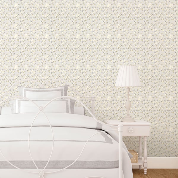 Cream floral wallpaper with anemone pattern in a white bedroom; features a metal ring-headboard bed, white & gray bedding, and a white nightstand with a pleated lamp.