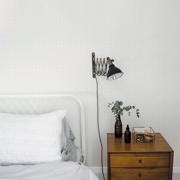 Beige scalloped wallpaper on a wall in a white room.