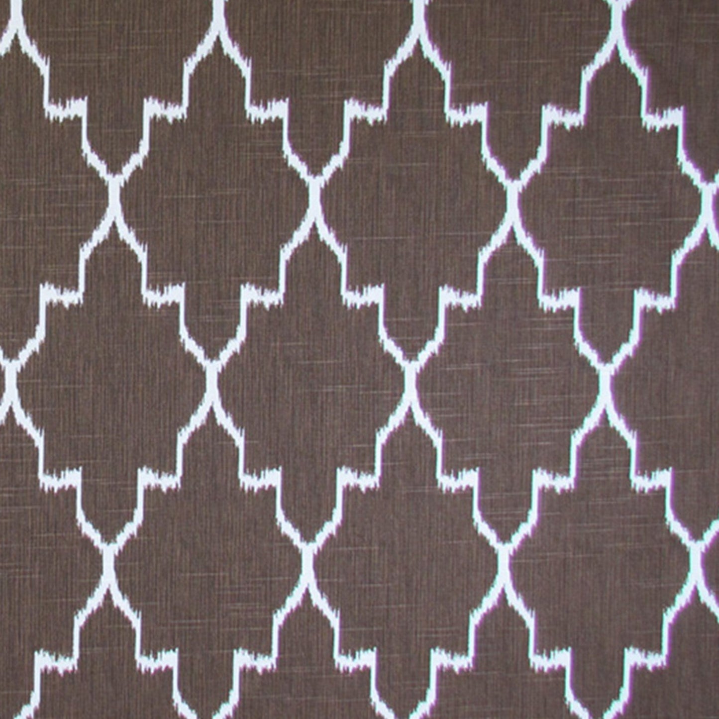 Brown ikat fabric with a white geometric print for upholstery or decor.