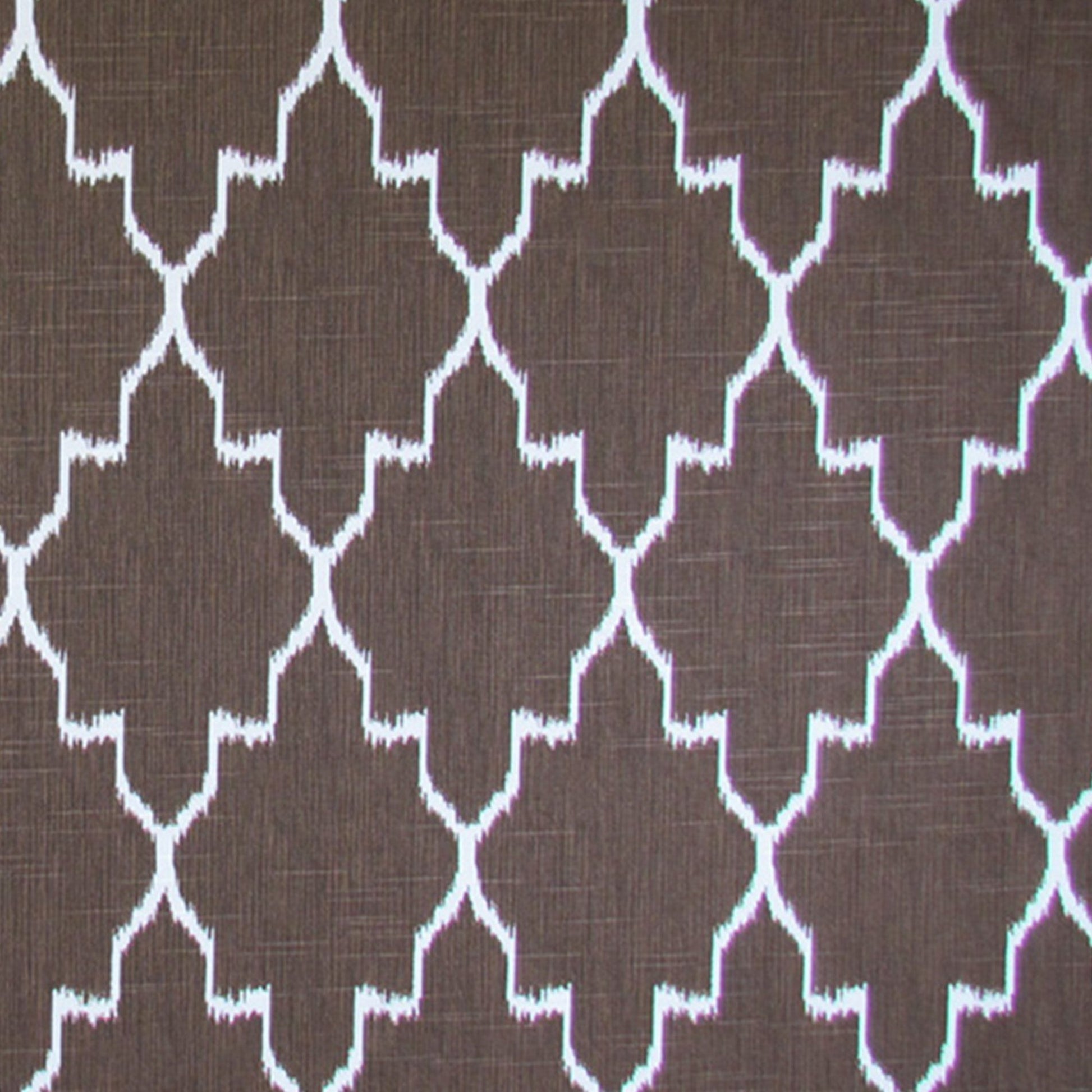 Brown ikat fabric with a white geometric print for upholstery or decor.