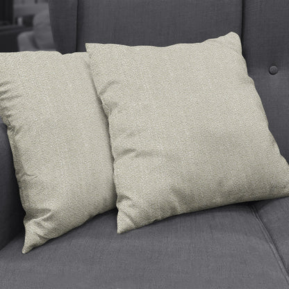 Two beige boucle-textured throw cushions on a dark gray sofa; solid fabric with a soft woven texture.
