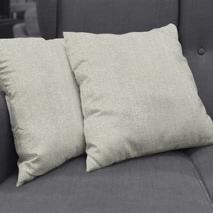 Beige textured square cushions on a dark gray sofa, decorative throw pillows.
