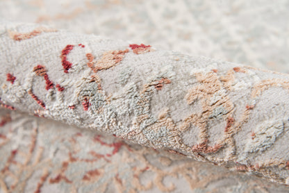 Close-up of a plush damask-pattern runner rug in cream-gray with peach and rust floral motifs.