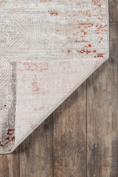 Distressed vintage 2'X8' runner rug in ivory and gray with pink and red accents, folded corner on wooden floor.