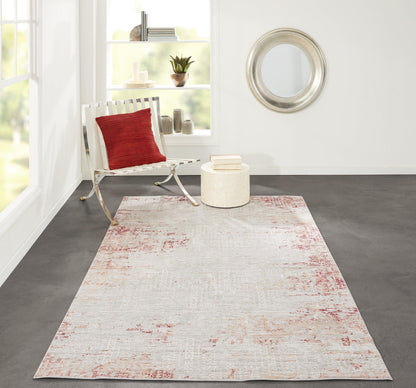 Bright modern room with a light distressed pink-red patterned runner rug, white chair and red pillow, silver-framed mirror.