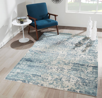 Blue mid-century armchair with wooden arms on a teal-gray abstract area rug beside a white side table.