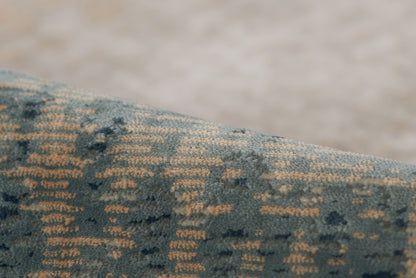Close-up of blue velvet rug with a gold geometric weave.