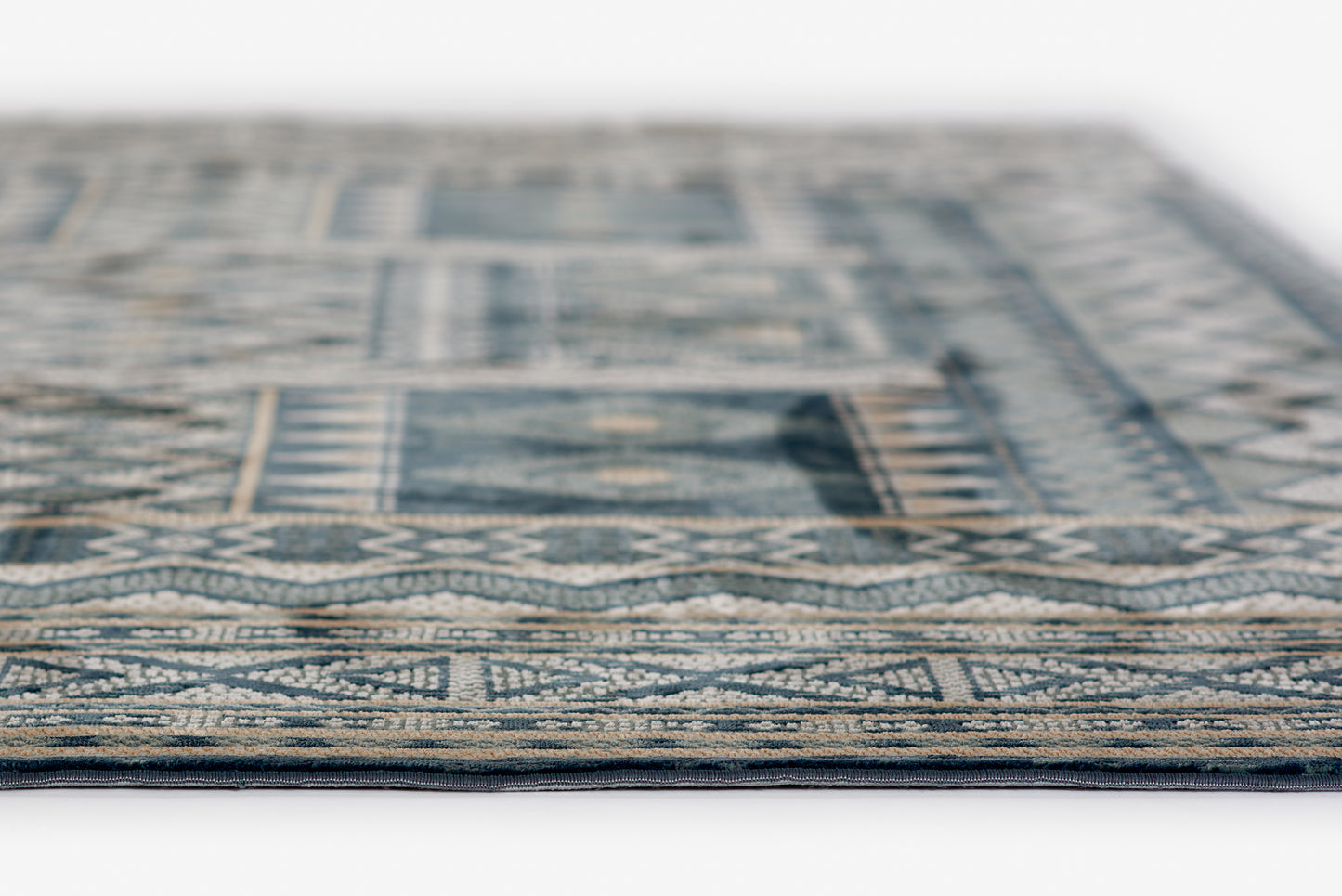 Blue and beige geometric rug, woven with traditional border pattern, close-up edge view.