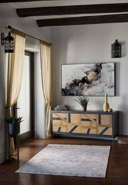 Gray 2' x 3' rug in a rustic living room with dark beams, beige curtains, abstract art, a geometric cabinet and a potted plant