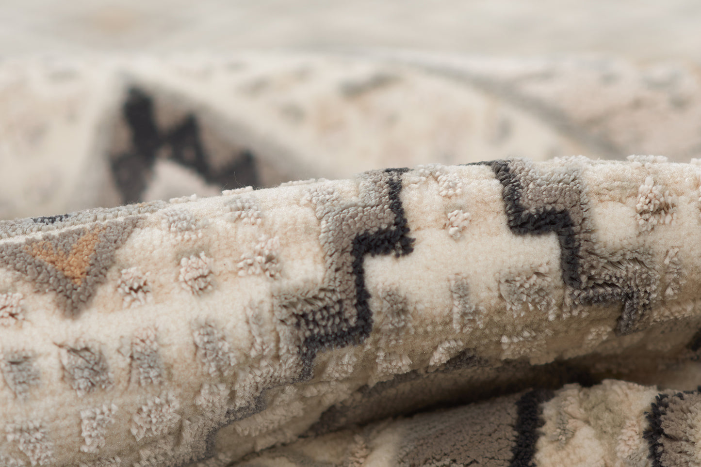 Ivory and beige woven rug with bold black geometric zigzag pattern; plush textured pile for living room decor.
