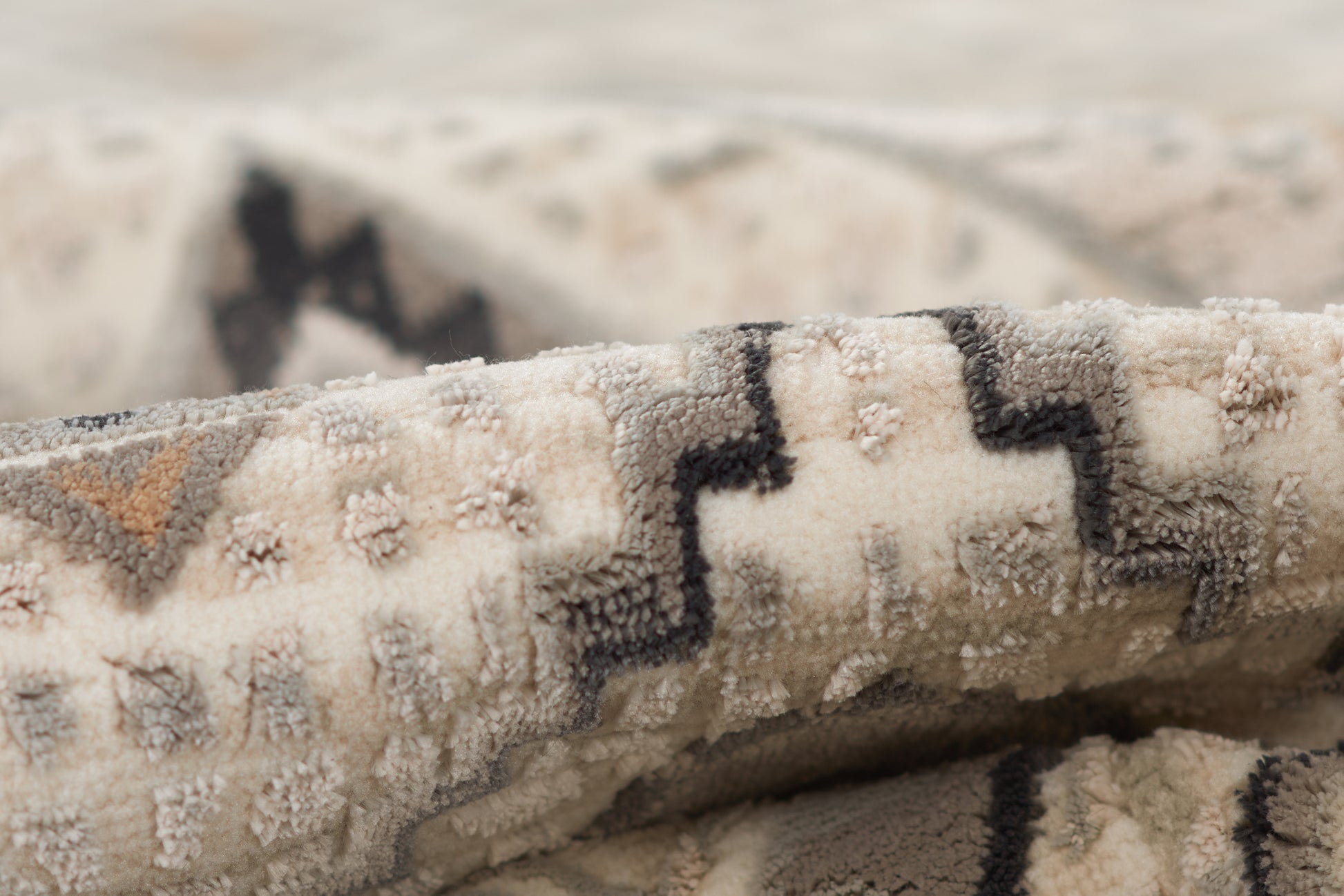 Ivory and beige woven rug with bold black geometric zigzag pattern; plush textured pile for living room decor.