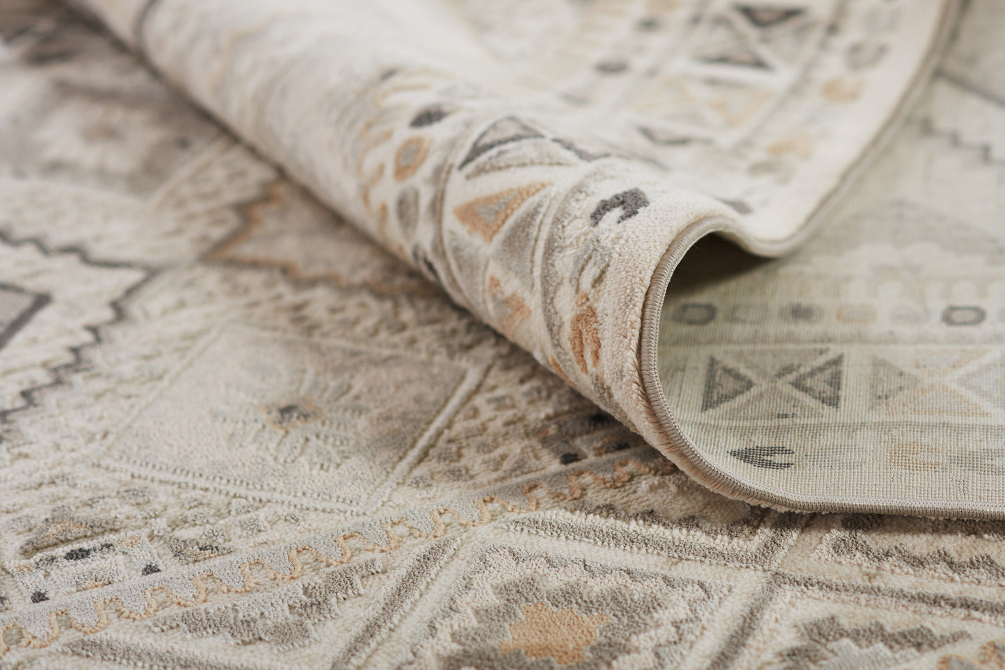Neutral geometric rug in ivory, beige and gray; woven low-pile with tribal motifs, rolled edge; 2' x 3'.