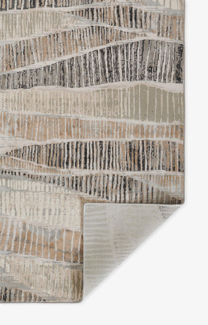 Neutral striped rug with irregular wavy bands in gray and taupe; textured woven surface with folded corner.