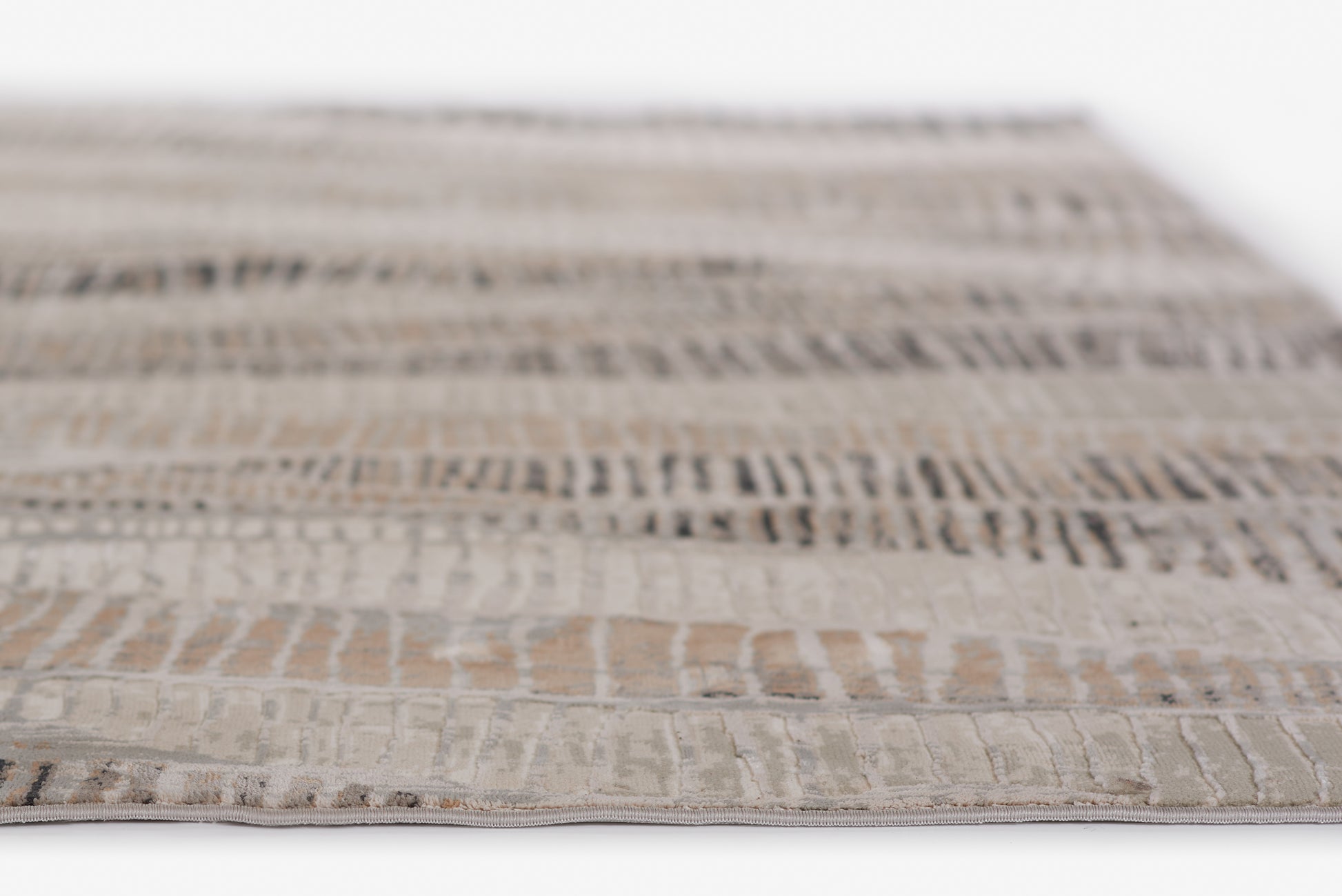 Neutral woven rug in cream, taupe & gray with a textured geometric pattern; rectangular, modern tribal style.