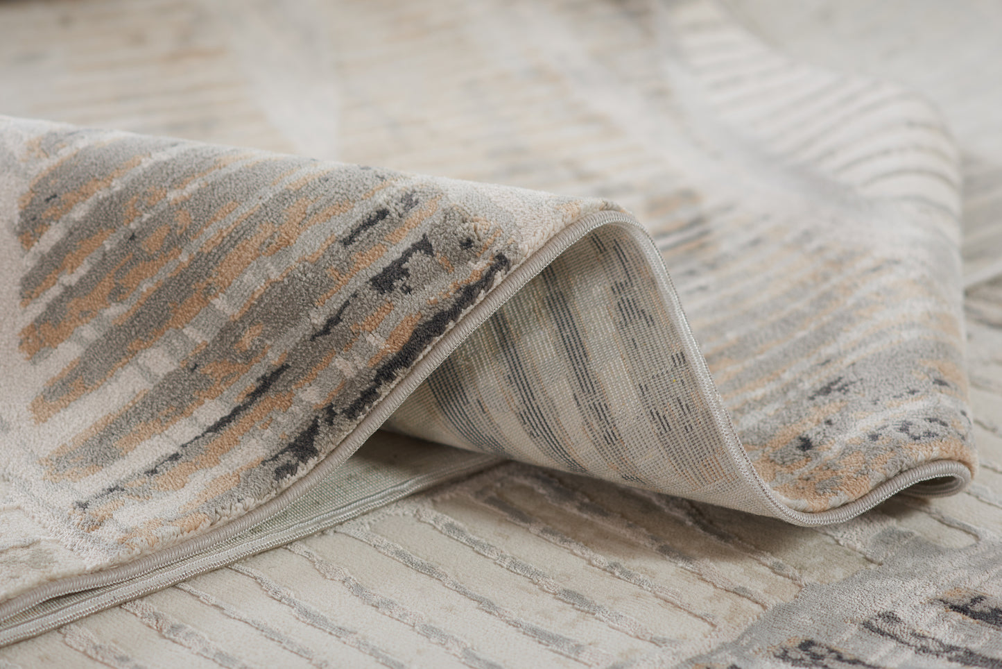 Neutral gray-beige striped woven rug with a distressed pattern and soft texture.