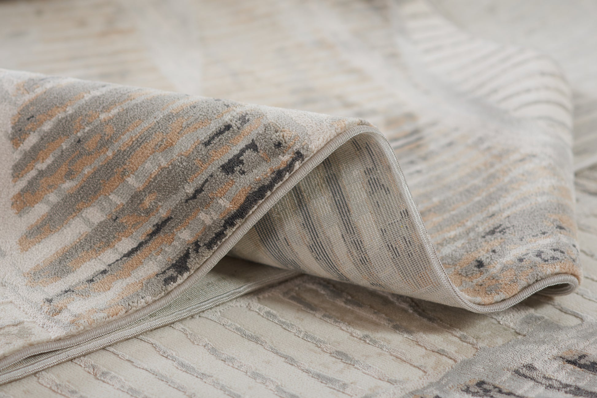 Neutral gray-beige striped woven rug with a distressed pattern and soft texture.