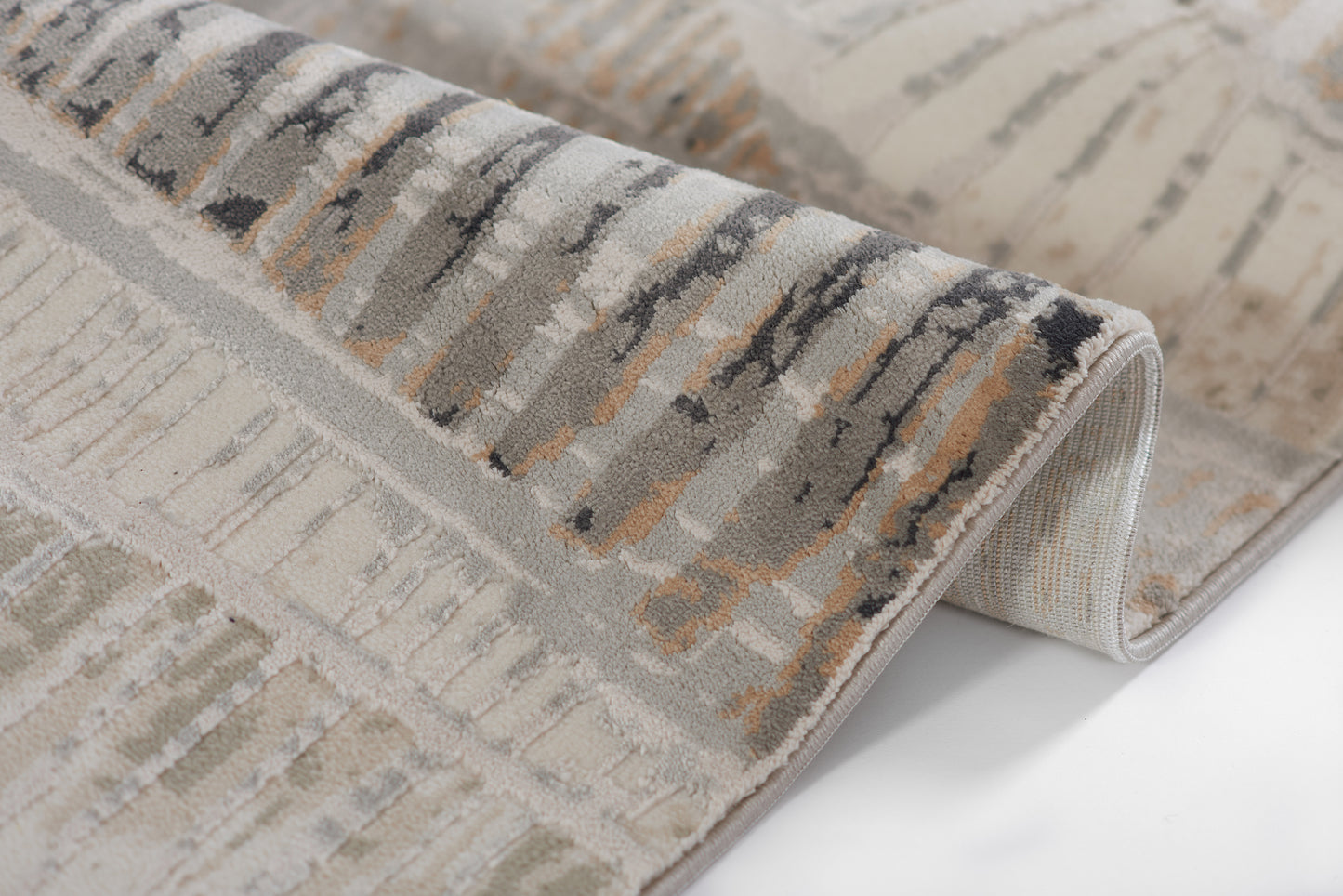 Abstract gray-beige area rug with ivory, charcoal brush-stroke pattern; plush pile and rolled edge.