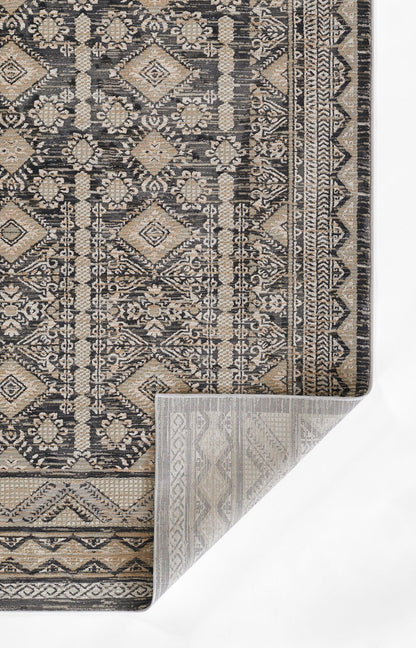 Dark beige and charcoal Oriental rug with an intricate geometric damask pattern; folded corner reveals a lighter backing.