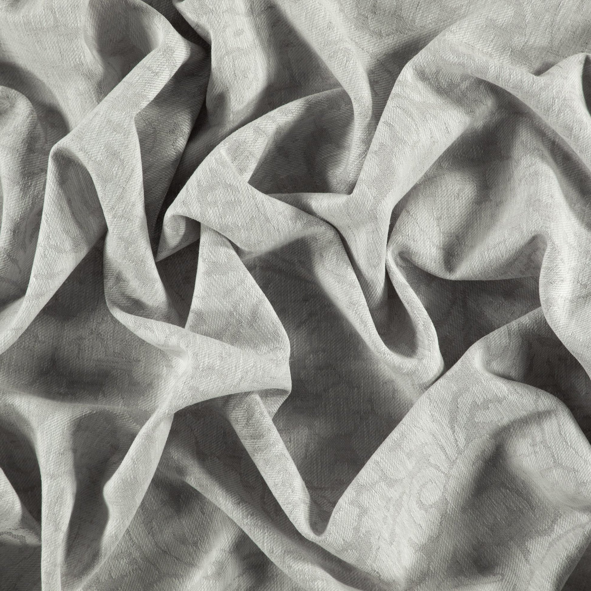 Light gray textured damask jacquard fabric with subtle pattern and soft draped folds.