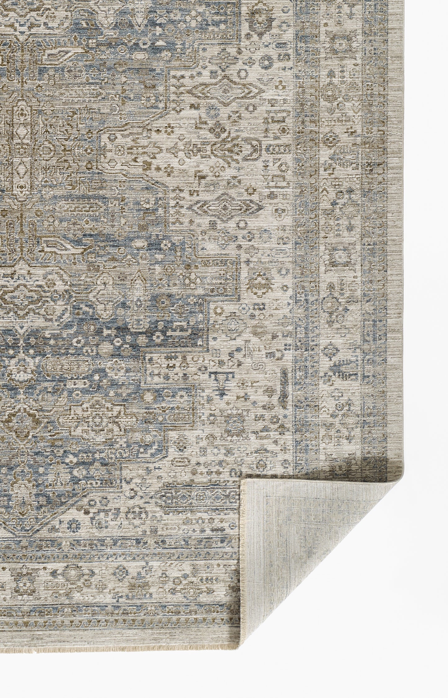 Blue and beige distressed oriental rug with intricate geometric floral motifs and bordered edges, corner folded.