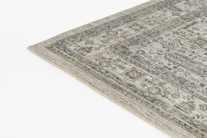 Beige and blue oriental rug with a floral border, distressed pattern, cropped corner view.