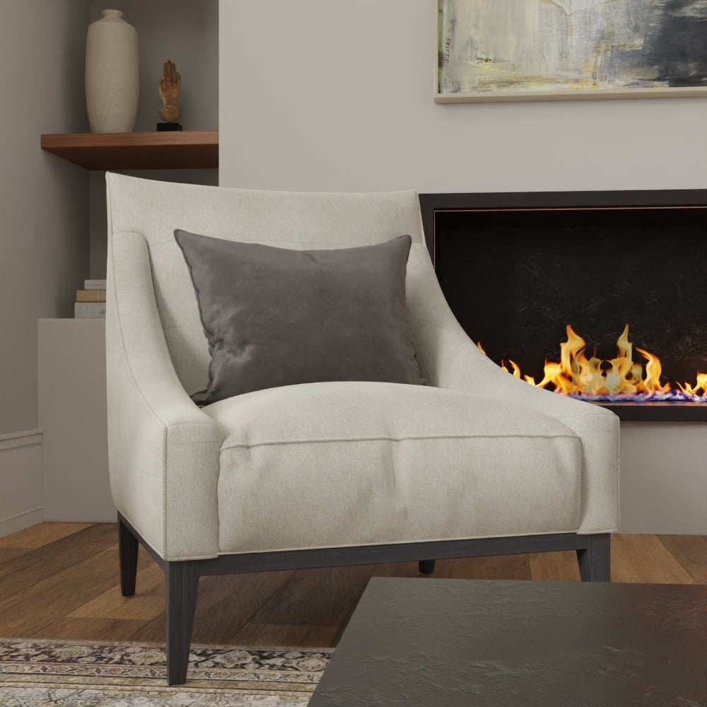 Gray Mercury solid fabric armchair with dark wood legs and a gray cushion in a cozy living room beside a lit fireplace.
