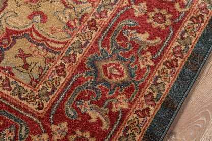 Ornate Persian-style area rug with red, beige, blue and gold motifs and a floral border on a wooden floor.
