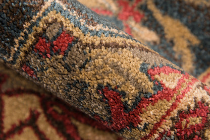 Close-up of a traditional oriental rug with warm brown, red and cream tones, blue accents, and a plush floral pattern.