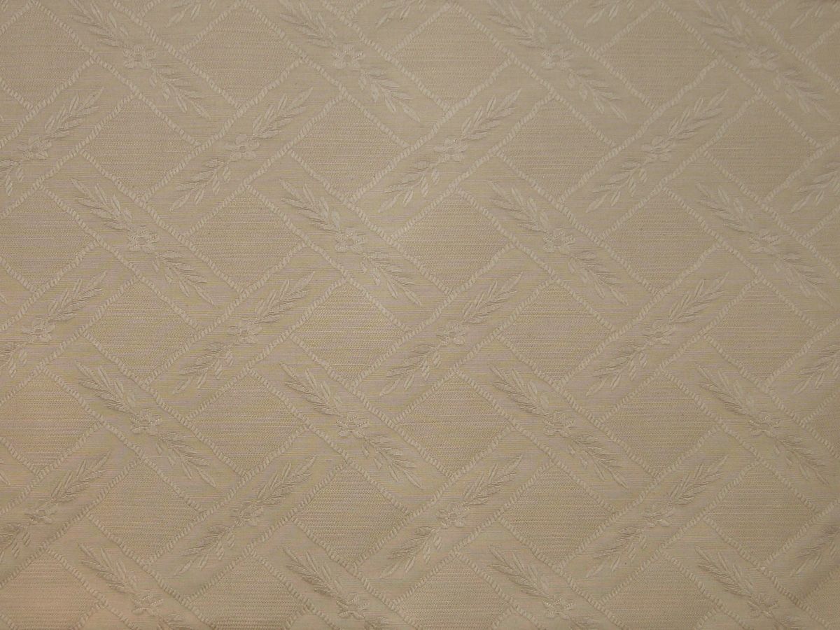 Beige latte woven fabric with embossed diamond lattice and laurel leaf motifs.