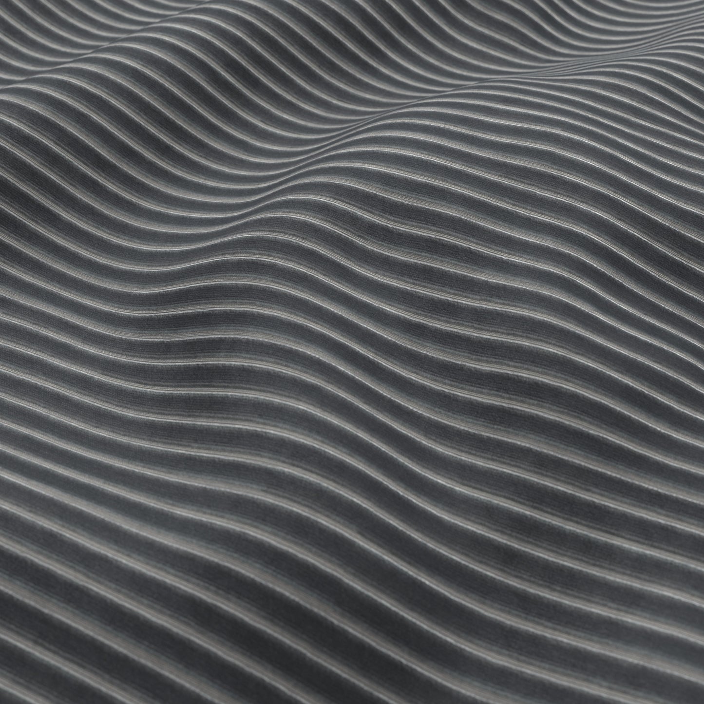 Close-up of charcoal blue corduroy fabric texture with ribbed ridges and a subtle sheen.