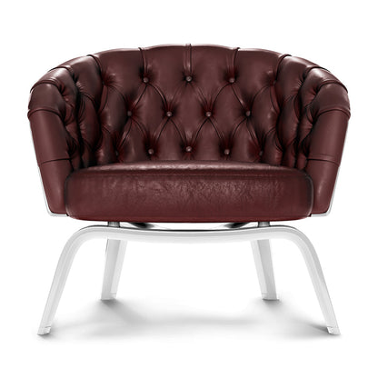 Burgundy tufted leather lounge chair with rounded arms and buttoned back, on white curved metal legs.